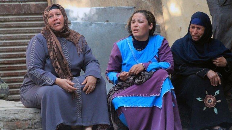 Egyptian relatives of supporters of ousted president Mohamed Morsi cry sitting outside the courthouse in the central Egyptian city of Minya