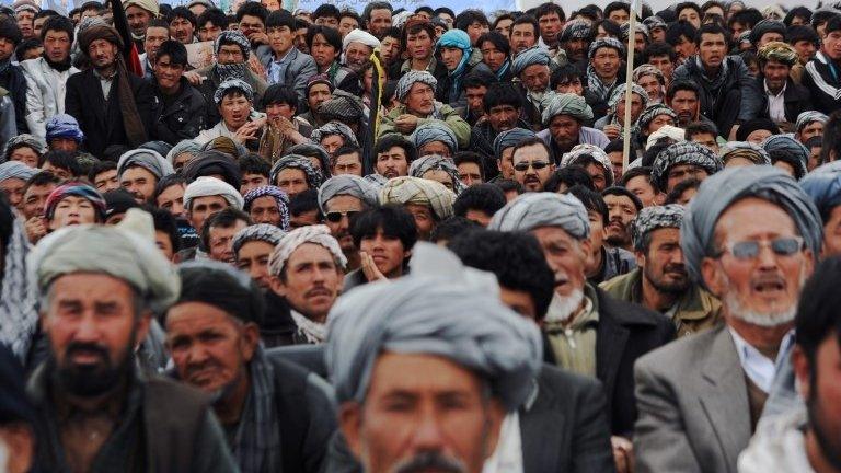 Afghan men crowd a field at a political rally during a campaign stop by presidential candidate Zalmai Rassoul in Bamiyan on April 1, 2014.