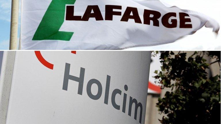 This combination of files pictures made on 04/04/14 shows a Lafarge flag and Holcim logo