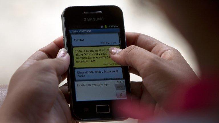 In this 3 March, 2014, photo, a woman uses her cellphone in Camajuani, Cuba.