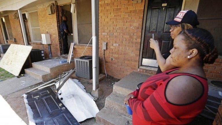 Residents look on as workers repair a front door, centre, at an apartment complex in Atlanta 10 April 2014