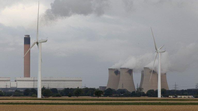 Wind turbines next to a coal power station