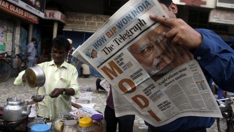 A man reads a newspaper with opposition leader Narendra Modi featured in the headlines.