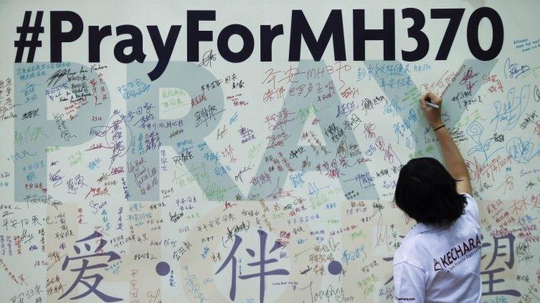 A woman writes a message on a board for family members of passengers onboard the missing Malaysia Airlines Flight MH370 at the Malaysian Chinese Association (MCA) headquarters in Kuala Lumpur, 6 April 2014