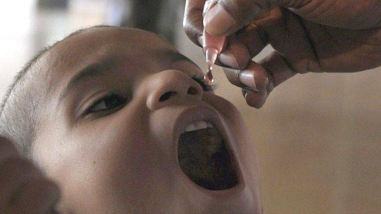 In this photograph taken on May 19, 2014, a Pakistani health worker administers polio vaccination drops to a child at the Karachi International Airport in Karachi.