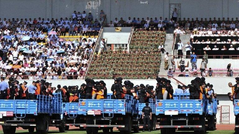 Trucks carrying criminals and suspects are seen during a mass sentencing rally at a stadium in Yili, Xinjiang Uighur Autonomous Region, 27 May 2014