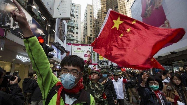 Protesters wave Chinese national flags during an anti-mainland tourist rally in Hong Kong"s famous Causeway Bay shopping district, 16 March 2014