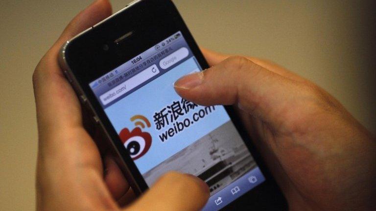 File photo: A man visits Sina's weibo microblogging site using an iPhone in Shanghai