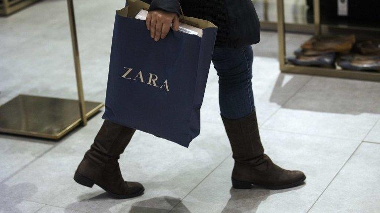 A woman holds a Zara bag inside a Zara store in central Madrid