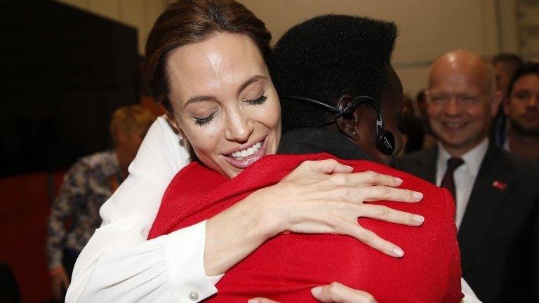 Actress and Special Envoy of the United Nations High Commissioner for Refugees Angelina Jolie embraces Esther Atim of Uganda at the "End Sexual Violence in Conflict" summit at ExCel on in London, 11 June 2014