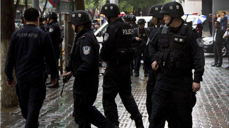 Armed policemen prepare to patrol near the site of an explosion in Urumqi, northwest China's Xinjiang, 22 May 2014