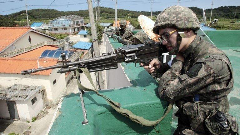 A soldier aims his weapon in Goseong, South Korea, 22 June 2014