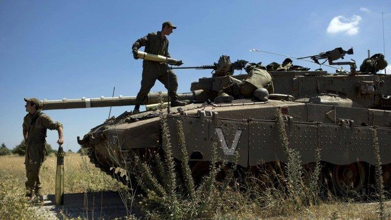 Israeli soldiers load shells in their tank in the Israeli-controlled Golan Heights, 22 June 2014