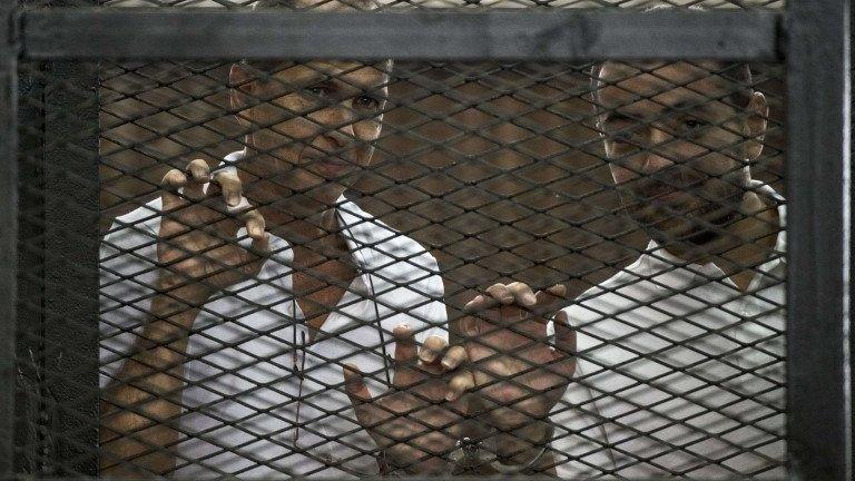 Al-Jazeera channel's Australian journalist Peter Greste (left) and Egyptian journalist Mohamed Baher stand inside the defendants' cage during their trial near Cairo's Tora prison, 1 June 2014