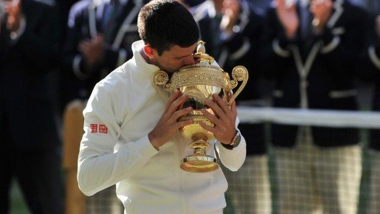 Novak Djokovic kisses the Wimbledon trophy