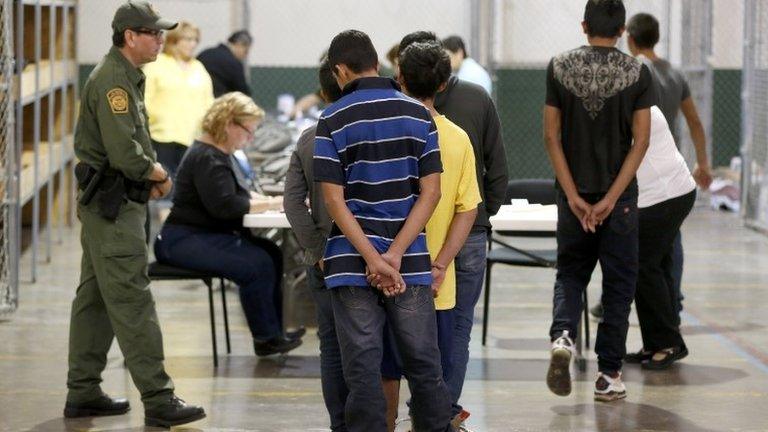 Boys wait in line to make a phone call as they are joined by hundreds of mostly Central American immigrant children that are being processed and held at the US Customs and Border Protection Nogales Placement Center in Nogales, Arizona 18 June 2014