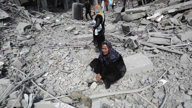 A Palestinian woman reacts at seeing destroyed homes in the northern district of Beit Hanun in the Gaza Strip during an humanitarian truce, 26 July 2014