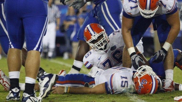 Florida Matt Patchan (71) and Marcus Gilbert (76) look on as Florida quarterback Tim Tebow lies on the turf after being sacked during an NCAA college football game against Kentucky in Lexington, Kentucky 26 September 2009