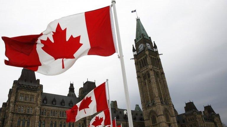 Canadian flags line the road around Parliament Hill during the National Day of Honour ceremony in Ottawa 9 May 2014