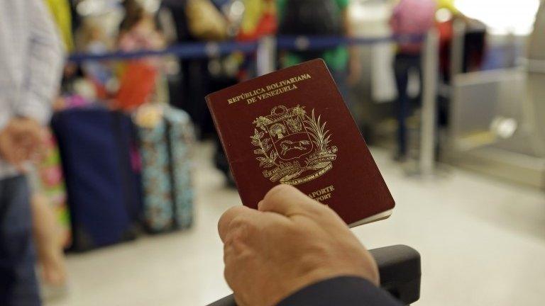 A man holds a Venezuelan passport in this photo taken on 25 June, 2014