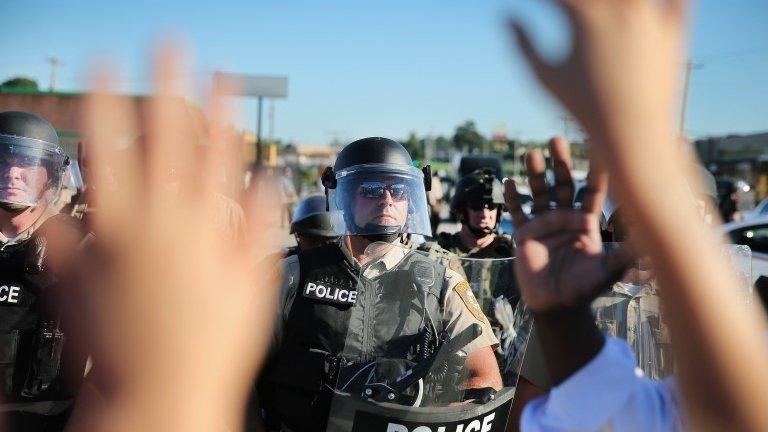 A child, who was being held by her mother who was protesting the shooting death of teenager Michael Brown, holds up her hands after police ordered them off the street by on August 13, 2014 in Ferguson, Missouri