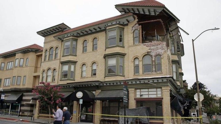 Two men walk past the earthquake-damaged building that housed the Carpe Diem wine bar Napa, California 25 August 2014