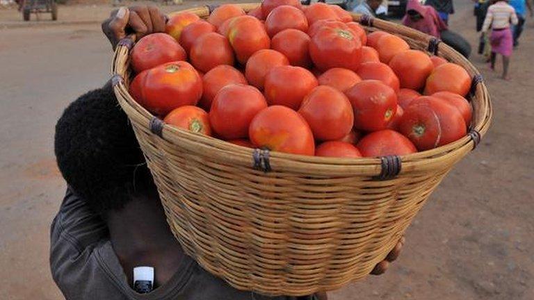 Market vendor carrying basket of fruit (Getty Images)