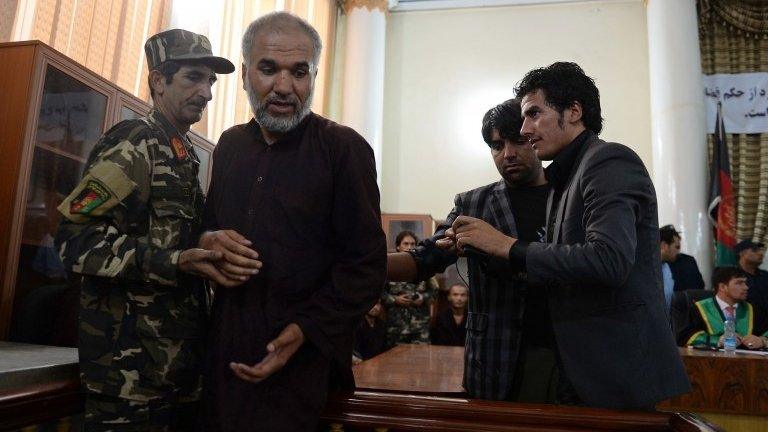 Azizullah (second left), the leader of seven men who gang-raped four women on 23 August, is brought up to testify in court in Kabul on 7 September 2014