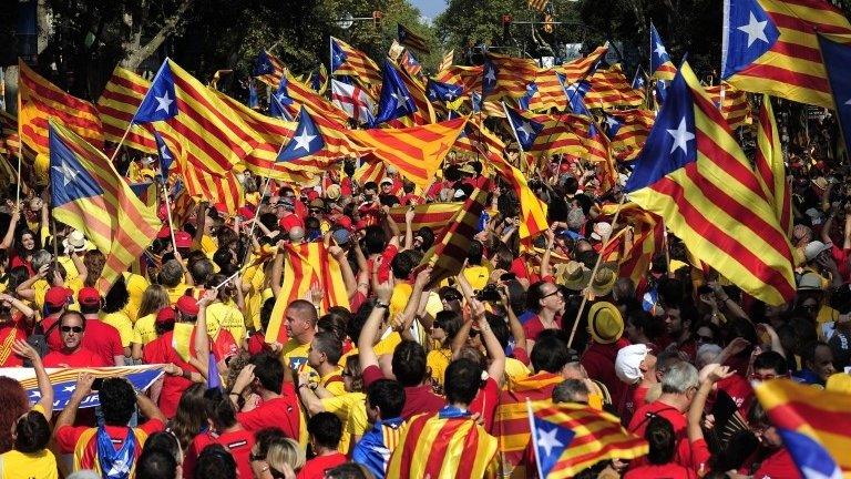 Catalans hold Catalonia pro-independence flags during celebrations of Catalonia National Day (Diada) in Barcelona on 11 September 2014