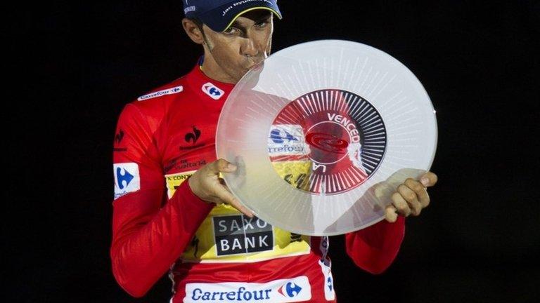 Tinkoff's Spanish cyclist Alberto Contador kisses the trophy on the podium after winning the 69th edition of La Vuelta