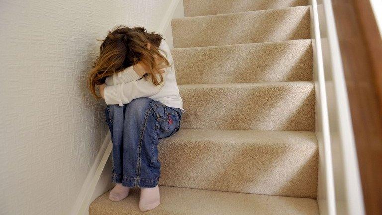 Girl sitting on stairs hiding face