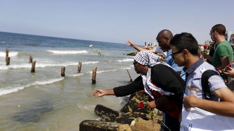 Gazans throw roses into the sea in Gaza City 18 September 2014