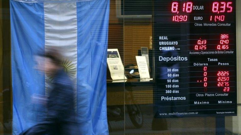 Woman walks past exchange store in Buenos Aires