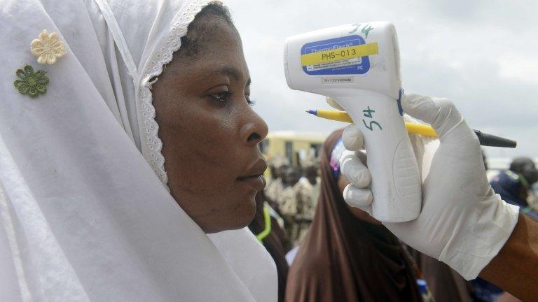 Woman having temperature taken