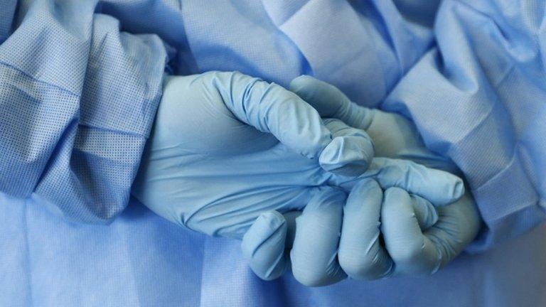 Hands in medical gloves