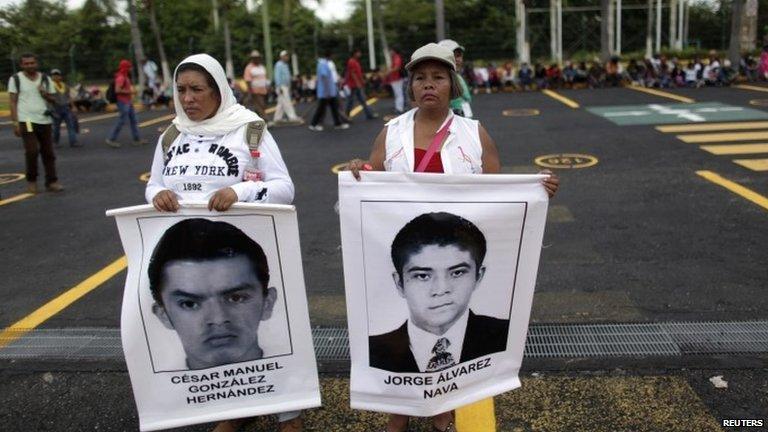 Relatives hold photographs of trainee teachers on the parking lot of the airport during a protest in Acapulco on 10 November, 2014