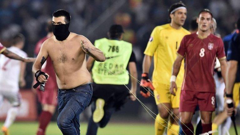 A Serbia fan invades the pitch during the match with Albania, 14 October