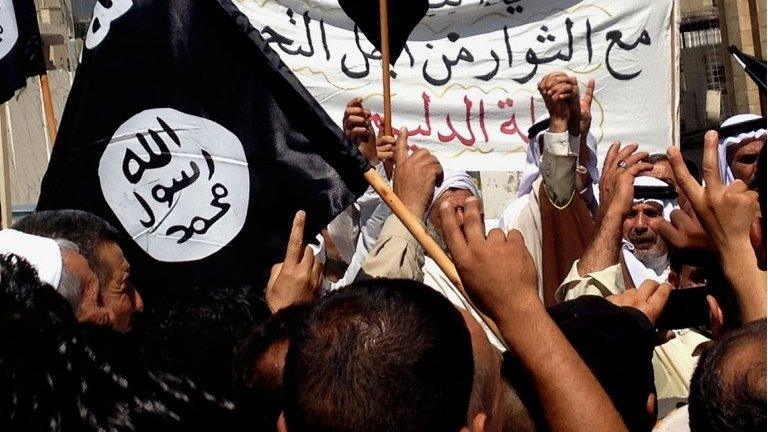 Islamic State supporters attend a rally outside the Nineveh provincial government headquarters in Mosul (16 June 2014)