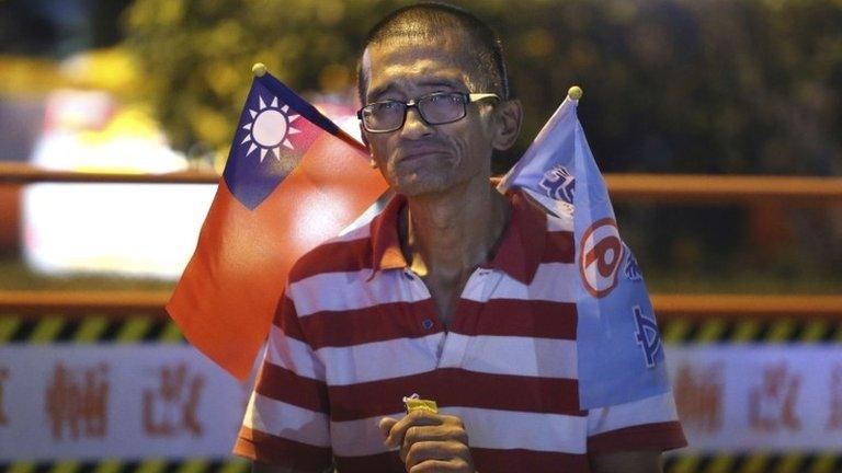 A man carrying a Taiwan national flag reacts after the KMT's Taipei mayoral candidate Sean Lien conceded defeat at the local elections in Taipei on 29 November 2014