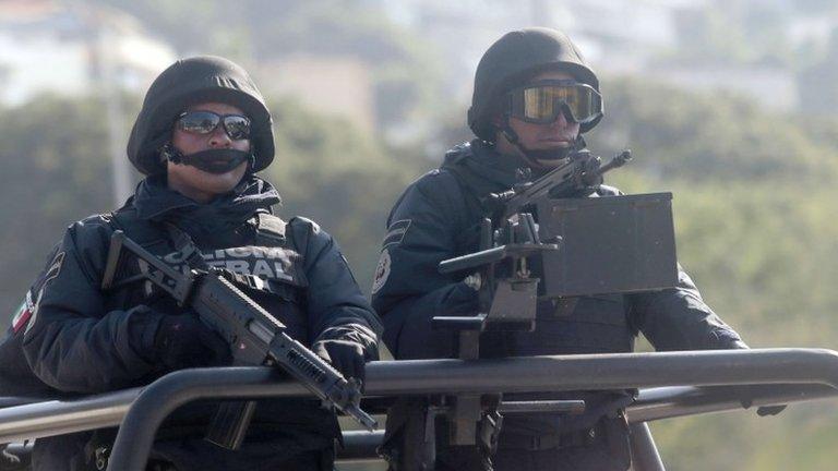 Mexican federal policemen patrol a street in Acapulco on 3 December, 2014