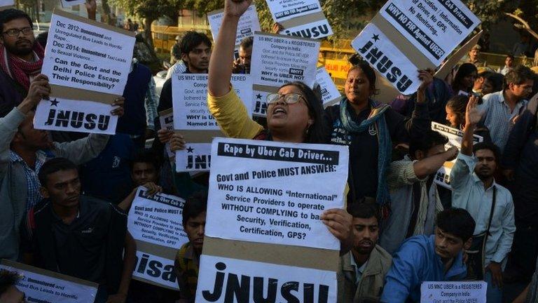 ndian residents hold placards and chant slogans as they take part in a protest against the alleged rape of a passenger by a driver working for the Uber taxi company in New Delhi on December 7, 2014