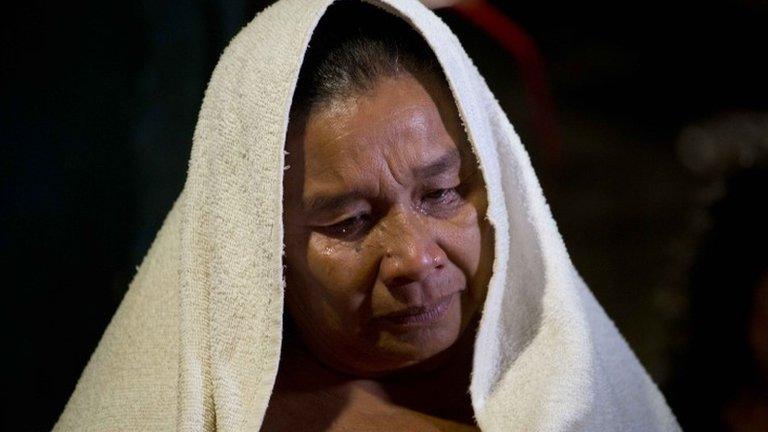 A woman prays at the Mora family home in the town of El Pericon on 7 December, 2014