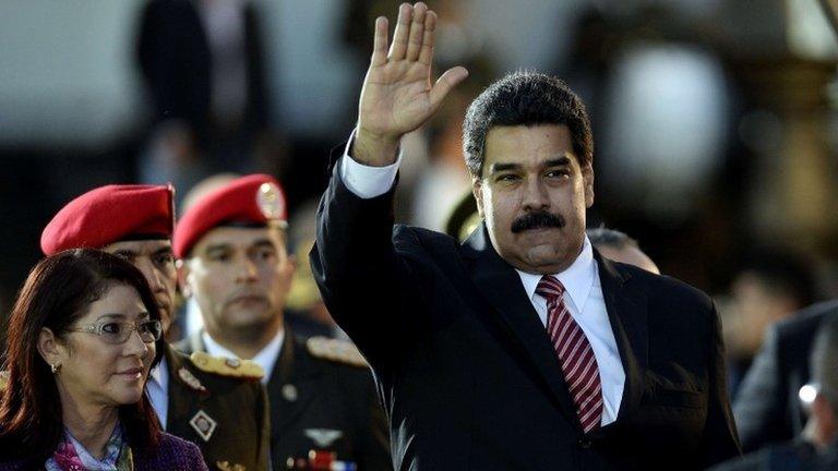 Nicolas Maduro waves next to First Lady Cilia Flores during the commemoration of the 190 years of the Battle of Ayacucho in Caracas, on 9 December, 2014.