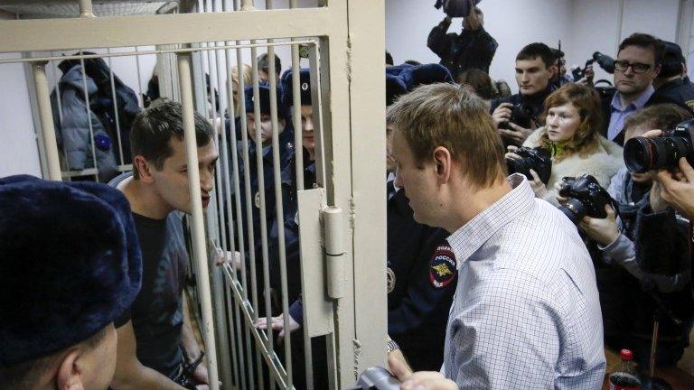 Alexei Navalny (right) speaks to his brother Oleg (left) after the brothers are given difference sentences by a judge in Moscow (30 December 2014)