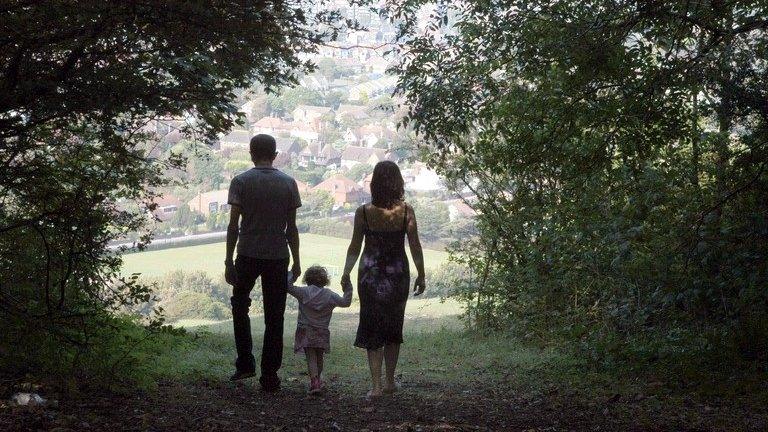 Mother, father and child walking in silhouette