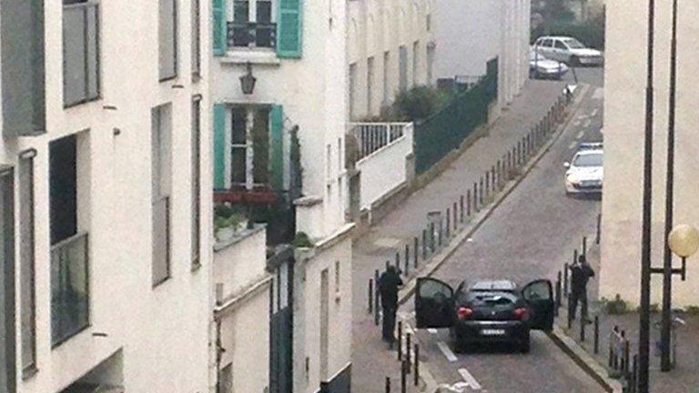 Gunmen (foreground) face police in Paris, 7 January