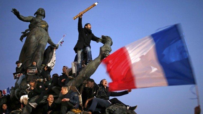 A man holds a giant pencil as he takes part in a solidarity march (Marche Republicaine) in the streets of Paris, 11 January 2015