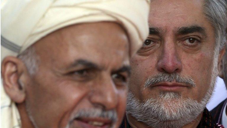 In this file photo taken Saturday, Oct. 4, 2014, Afghanistan's Chief Executive Abdullah Abdullah, right, listens as President Ashraf Ghani speaks