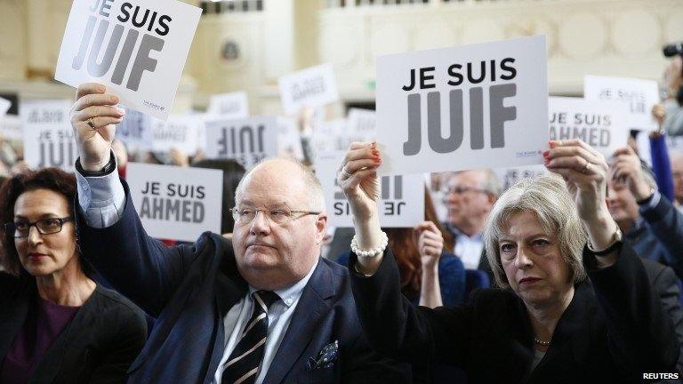 Eric Pickles and Theresa May hold up signs saying "I am Jewish"