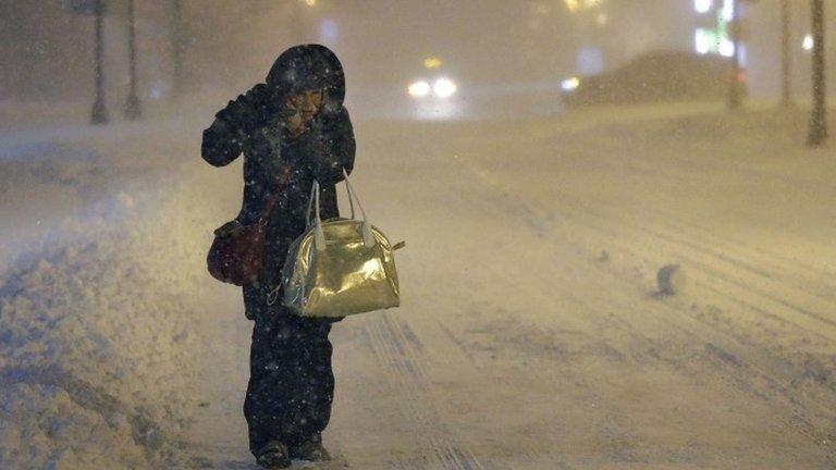 Denise Young, of Lynnfield, Mass., a nursing supervisor at Massachusetts General Hospital, adjusts her hood while walking to work, early Tuesday 27 January 2015 in Boston. Massachusetts